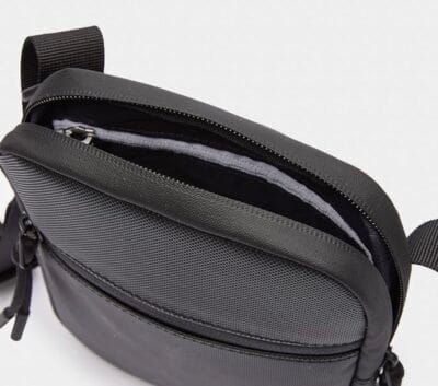 Stilvolle Lacoste Herren Schultertasche: Reißverschlusstaschen, verstellbarer Riemen, grünes Krokodil-Logo, PVC-Material.