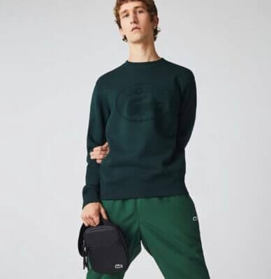 Lacoster Schultertasche in schwarz mit deinem Model welches die Tasche in der Hand hält